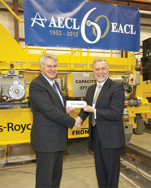 Rolls Royce Civil Nuclear Canada General Manager Neil Alexander hands AECL President Robert Walker the keys to the automated fuel handling, transportation and storage system on May 16, 2012 at the Rolls Royce Peterborough facility.