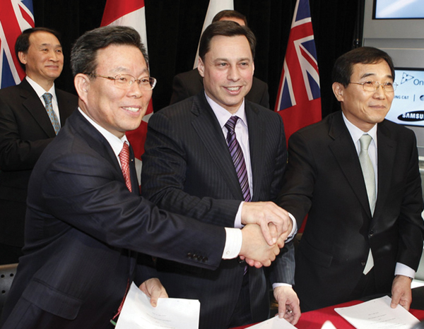 Energy and Infrastructure Minister Duguid shaking hands with Samsung officials