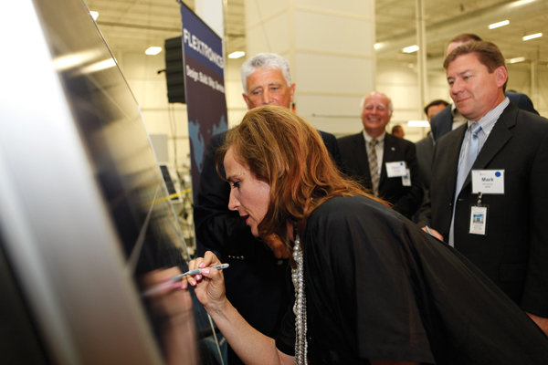 Sandra Pupatello, Ontario Minister of Economic Development and Trade, signs a photovoltaic panel off Flextronics' new production line in Newmarket.